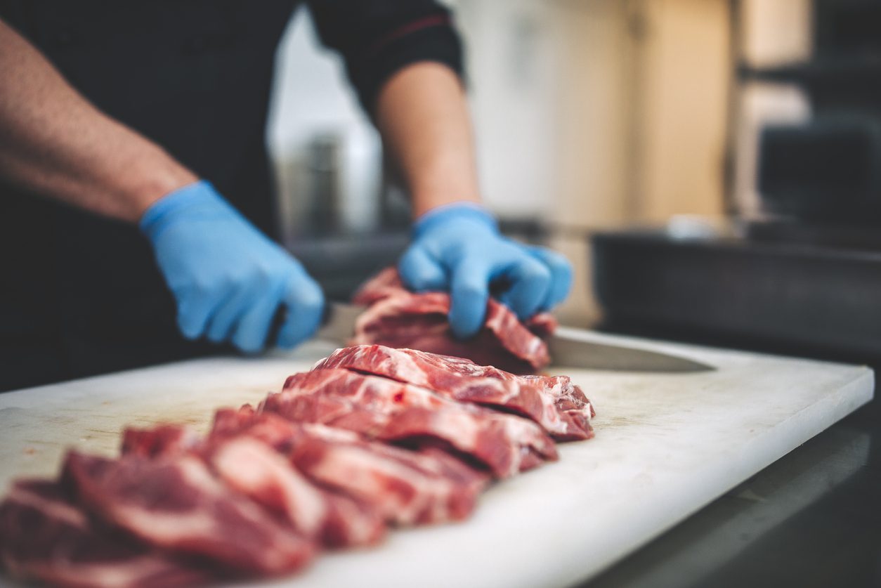 Image of a butcher cutting meat